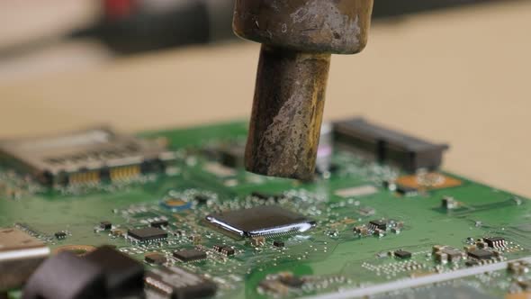 Closeup of a Technician Repairing a Computer Chip with a Soldering Iron