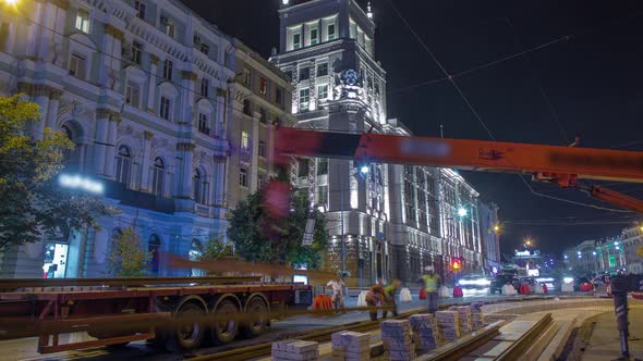 Orange Construction Telescopic Mobile Crane Unloading Tram Rails From Truck Night Timelapse