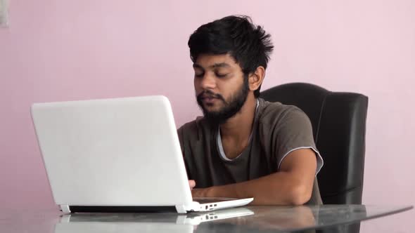 Beard man watching stock market crashing news on laptop and reacting