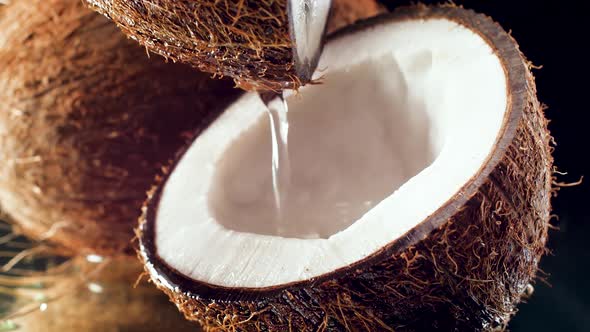 Closeup Slow Mtoion Video of Pouring Water or Milk in Coconut Half