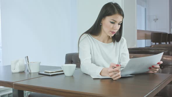 Young Busy Woman Preparing Project Report Sitting in the Cafe