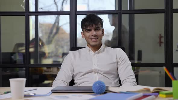 Positive Hindu Man Posing on Camera at Workplace