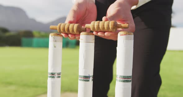 Cricket umpire preparing the stumps