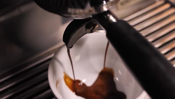 Making espresso in professional coffee machine high angle close up shot