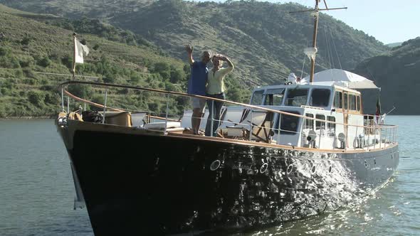 Senior couple waving from a boat