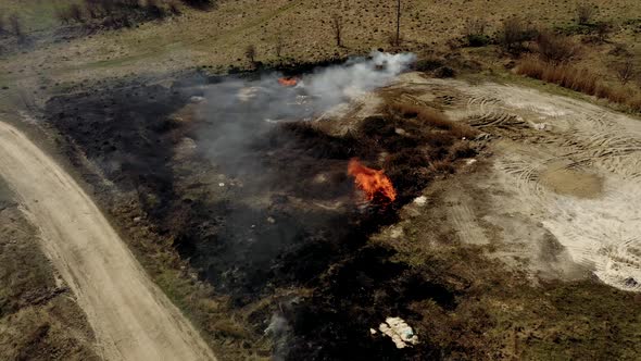 Air pollution caused by wildfires, clouds of smoke above the burning field, aerial footage.