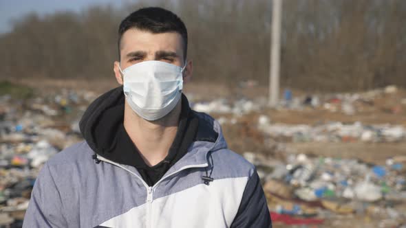 Guy Wearing Protective Mask From Virus Outdoor. Portrait of Young Man with Medical Face Mask Stands