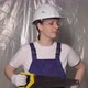 Woman Builder in Blue Overalls and White Hard Hat Helmet with Hand Saw - VideoHive Item for Sale