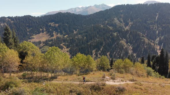 Hiker with Backpack Walking in the Mountains