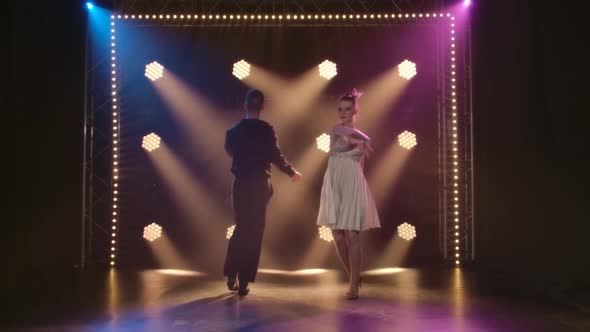 Ballroom Dancers Are Dancing on a Black Background with Studio Stage Lighting. Slow Motion.