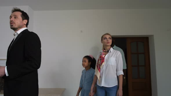 Family Looking Around House with Real Estate Agent