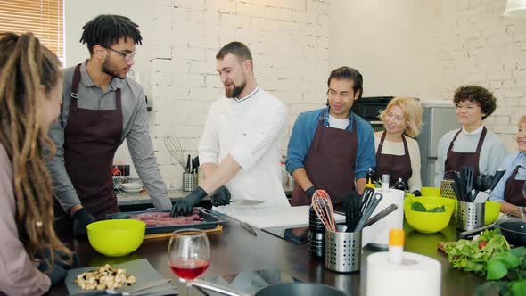 Diverse Group of People in Aprons Cooking Food During Cookery Courses in Kitchen