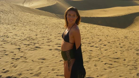 Gorgeous Female Model in Two Piece Bikini Posing with Sand Dunes in Background