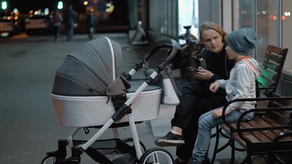 Woman with baby and elder son spending evening outside