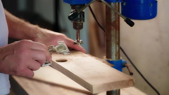 Joiner is Installing Furniture Loop in Wooden Detail Working in His Workshop Closeup of Hands
