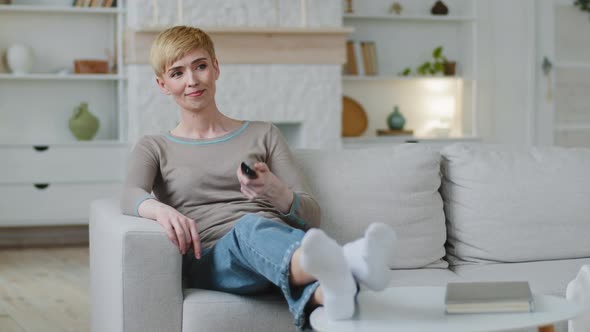 Woman Switching Channels Choose Comedy Film for Funny Pastime Relaxing on Comfortable Cozy Sofa