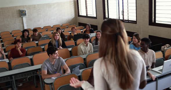 Mature teacher working with students inside classroom at school university