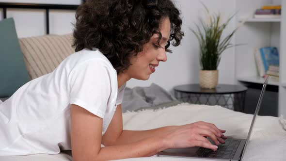 Smiling Hispanic Curly Woman Student Study Uses Laptop Distance Education