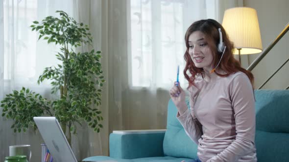 Young Business Woman Wearing Headphones Communicating By Video Call.