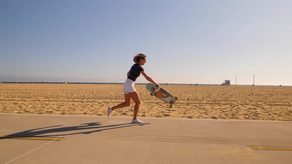 Woman Riding Longboard Then Catch On A Sunny Summer Day. - side view