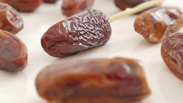 Palm dates  exotic eastern fruit on white background slow tilting   4K 2160p UltraHD footage - Tasty