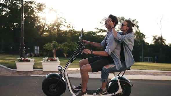 Young Couple on Dating Riding an Electronic Minibike on the Street