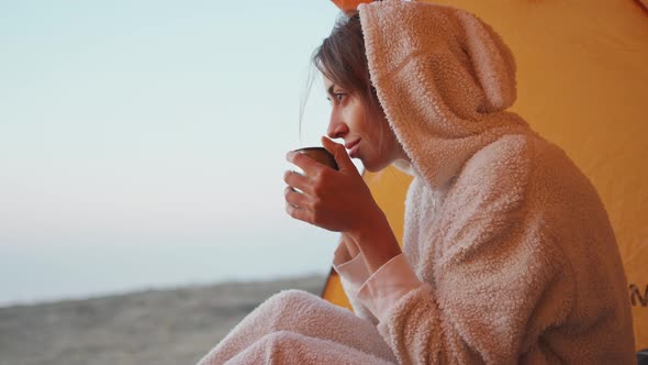 Closeup Portrait of Joyful Attractive Woman in Funny Pajama Sitting in Tent and with Mug Hot Coffee
