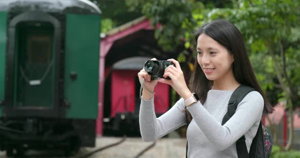 Woman Travel and Taking Photo on Digital Camera at Train Station