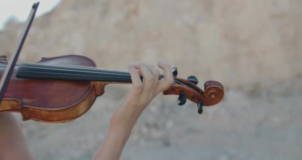 Female Fingers Moving Through the Strings During Playing the Violin at Cliffs