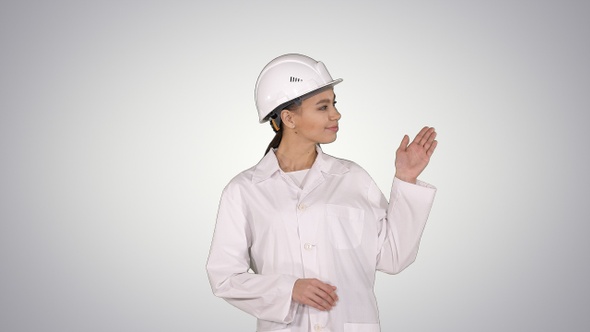 Mature Engineer Woman in Hard Hat Indicating to The Product