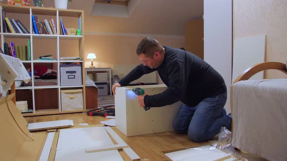 A Man With Screwdriver Assemble Furniture