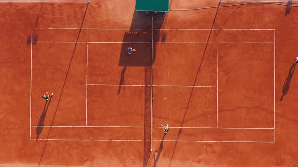 Aerial View. Players Are Playing Tennis on Orange Court
