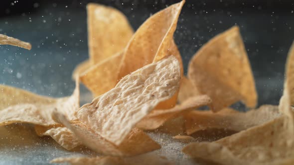 Tortilla chips sprinkled with salt. Slow Motion.