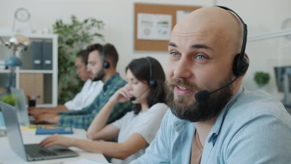 Attractive Guy Wearing Headset Talking to Client Working in Technical Customer Support in Office