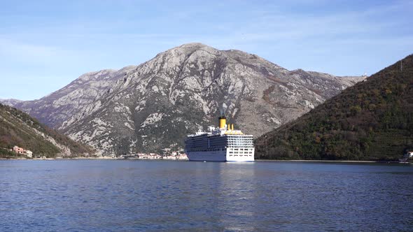 Large Cruise Ship Stands in the Bay Against the Backdrop of Mountains