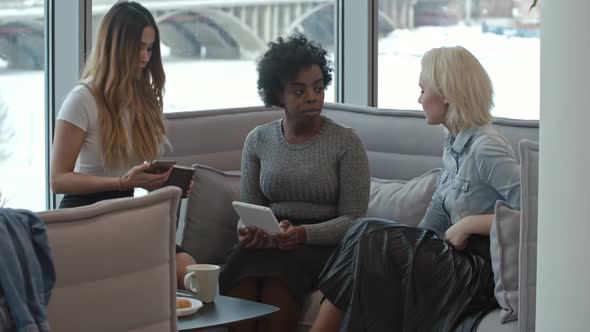 African Woman Chatting with Friends in Cafe