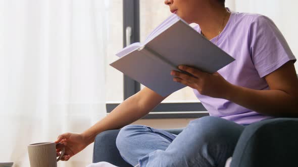 Happy African American Woman Reading Book at Home