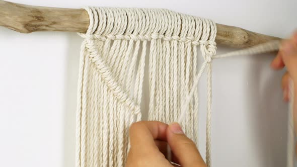 Macrame A woman makes home decor in Boho style. Woman making handmade decor weaves macrame