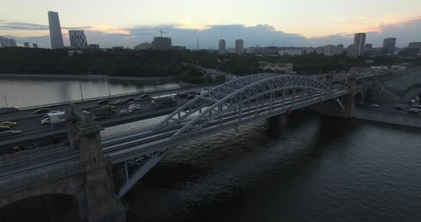 An Aerial View of a Railway Bridge Over the River Against the Evening Urban View