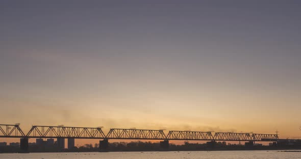 Timelapse of City River Bank, Sun Rays, Blue Sky and Railway Bridge Over Horizont, Summer Sunrise