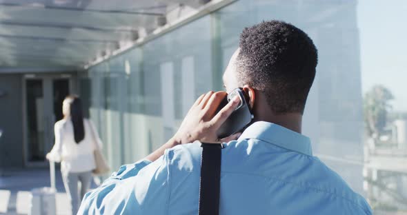 Video of back view of african american man walking and using smartphone