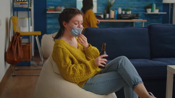 Woman Holding Beer Bottle Drinking Looking at Camera