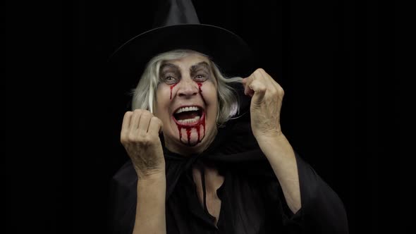 Old Witch Halloween Makeup. Elderly Woman Portrait with Blood on Her Face