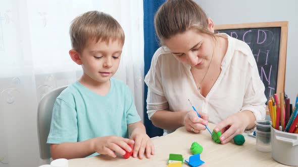 Smiling Mother Teaching Her Little Son Sculpting and Moulding Shapes with Colorful Clay or