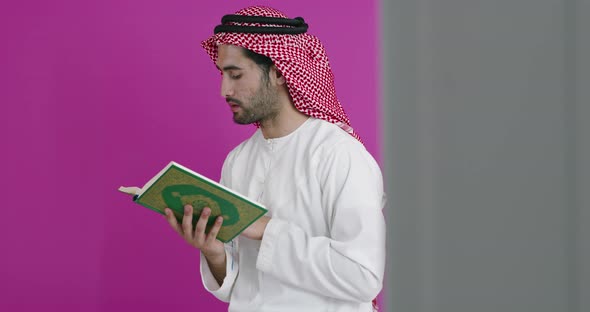 Young Arabian Muslim Man in Traditional Clothes Praying Reading Quran