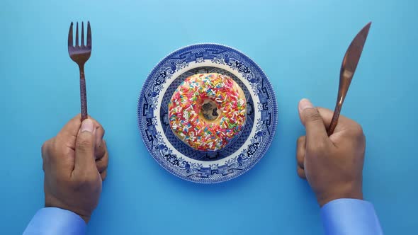 Man Hand Holding Knife and Fork Waiting for Eating Donuts