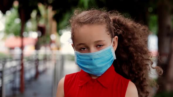 Child a Little Girl 78 Years Old Stands on the Street Wearing Protective Masks Against the Covid19