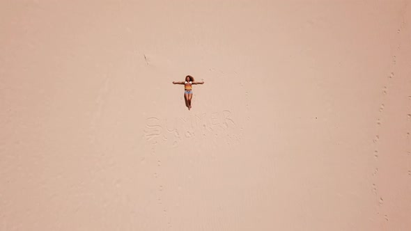 Happy free caucasian woman lay down on the sand at the beach enjoying the summer holiday