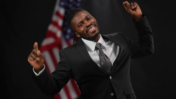 Cheerful Handsome African American Male Politician in Elegant Suit Dancing in Camera Flashes at