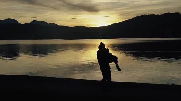 Silhouette of Kissing Couple Against Sunset at Mountain Top